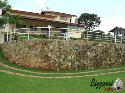 Muro de pedra construído com pedra moledo para formar o platô para a construção da piscina.
