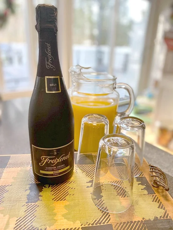 bottle of champagne and glasses filled with orange juice