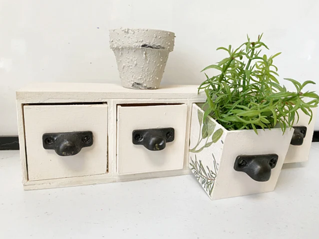 set of drawers with plant and pot