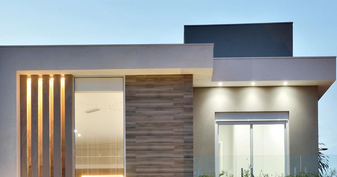 Fachada de sobrado contemporâneo com pé direito valorizado por