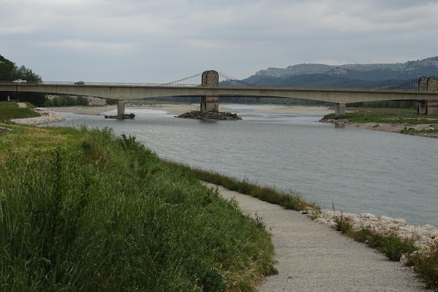 Steinerne, graue Brücke spannend über den Fluss, Berge im Hintergrund, Mallemort