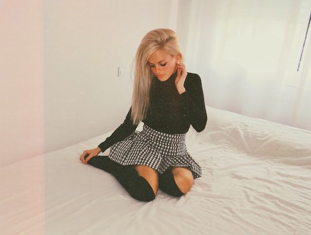 Alejandra Colomera con jersey negro, falda de cuadros vichy negros y calcetas negras
