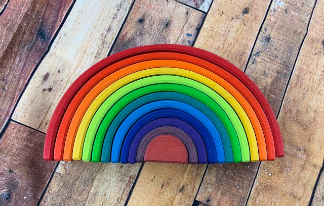 A photo of a wooden toy in all of the colours of the rainbow from Grimm's