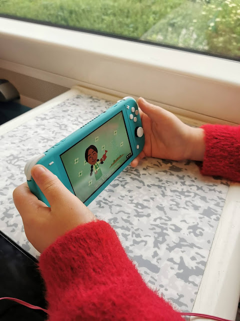 A girl playing a blue Nintendo Switch