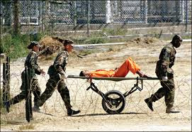 Hunger striker being taken away on a gurney at Guantanamo Bay