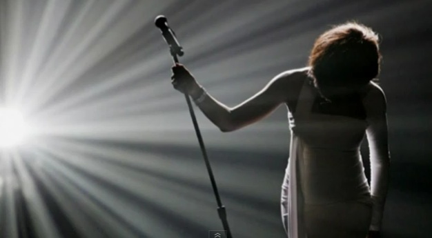 {applause} Whitney Houston bowing at microphone, backlit in shadow