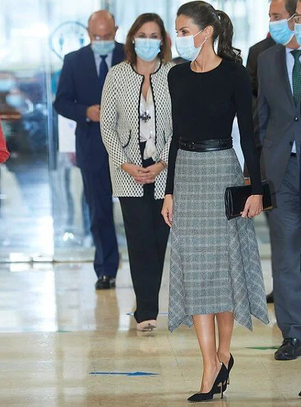 Queen Letizia wore a check wool skirt from Massimo Dutti, and black cashmere sweater from Hugo Boss. Carolina Herrera pumps and clutch
