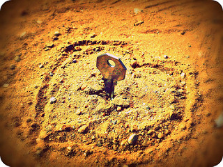 Llave clavada en el centro de un corazón pintado en la arena