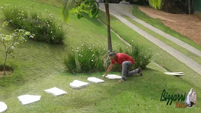 Bizzarri, da Bizzarri Pedras, trabalhando, iniciando a execução dos caminhos de pedra no jardim sendo o tipo de caminho com pedra com junta de grama em casa em condomínio em Mairiporã-SP.
