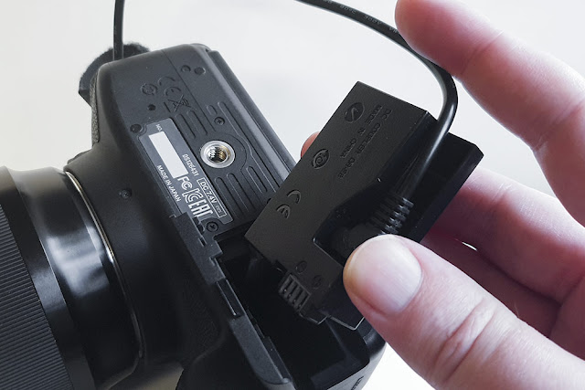 Showing inserting the Dummy Battery into the camera Step1