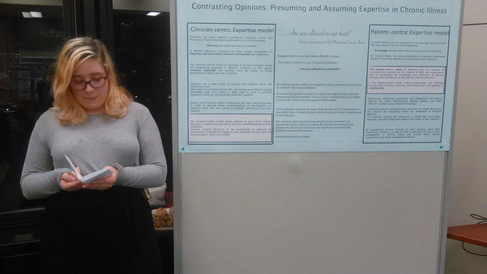 Photo of a woman standing next to a poster board.