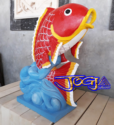 Patung air mancur bentuk Ikan hias yang dibuat dari batu alam putih atau batu alam paras jogja yang di cat merah