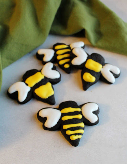 It is always fun to have a cookie cut in a pretty shaped and decorated with frosting, but you aren't limited to sugar cookies. There are lots of flavors and types of cookies you can roll and cut, here are a few of our favorite recipes black cookies cut in the shape of bees and decorated with yellow and white royal icing