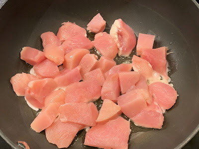 Diced chicken breast in a frying pan