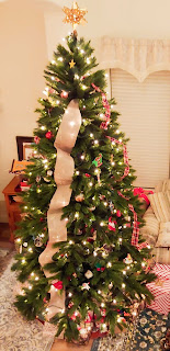 Beautifully decorated Christmas tree with a golden star at the top and presents underneath