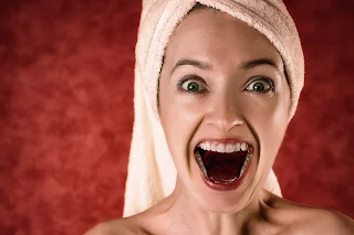 woman looking shocked with clear skin and towel wrap on head