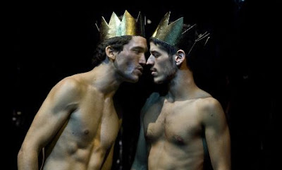 Foto de dos actores desnudos con coronas mirándose entre amenazantes y llenos de deseo en la obra El público de Federico García Lorca