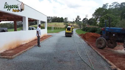 Execução da calçamento de pedra em rua de pedra com as guias de pedra em entrada da sede da fazenda em Atibaia-SP. Calçamento com pedrisco cinza com espessura de 3 cm.