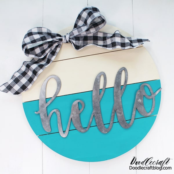 How to Make a Circle Wood Sign!   Make the perfect wood circle hello sign. These circle signs are all the rage and they are a perfect alternative to a wreath or door hanging.     Make a darling hello sign with a wooden circle pallet, some paint, ribbon and a galvanized hello!