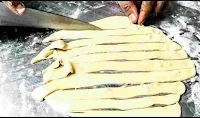Cutting a rolled dough into pieces for making parotta dough ball