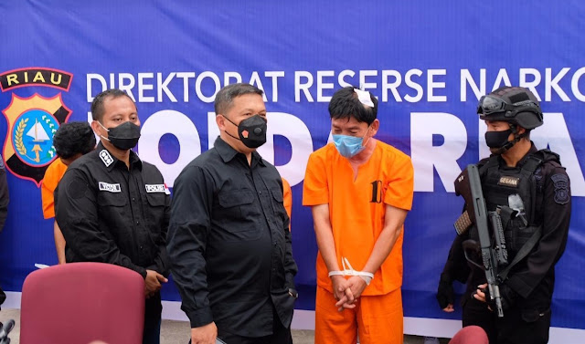 Riau - majalahglobal.com: Dit Res Narkoba Polda Riau mengukir prestasi yang luar biasa karena mengungkap peredaran Narkoba sebanyak 20 Kg Shabu yang melibatkan Anggota Polri.  Pada Senin 12 Oktober 2020 pukul 08.20 WIB, Tim Dit Res Narkoba Polda Riau melakukan pengejaran terhadap sebuah mobil merek Avanza warna putih BM 1236 RX berisi  2 orang diduga pengedar narkoba.   Ketika mobil itu dihadang oleh Tim, 2 tersangka melarikan diri masuk ke dalam hutan (meninggalkan mobil). Kemudian dilakukan penggeledahan mobil, dan ditemukan 3 (tiga) buah tas ransel berisikan shabu lebih kurang sebanyak 20 Kg.  Setelah 3 hari tim melakukan pengejaran, pada Kamis (15/10/2020), tim menemukan posisi kedua tersangka berada di Pulau Rupat, Kabupaten Bengkalis, dan berencana akan melarikan diri ke negara Malaysia secara ilegal. Selanjutnya, tim melakukan pengejaran dan berhasil mengamankan kedua tersangka tersebut. Pada saat pengembangan di Dumai, tersangka berusaha melarikan diri sehingga petugas melakukan tindakan tegas terukur terhadap kedua tersangka lalu dibawa ke Rumah Sakit Bhayangkara Polres Dumai. Setelah mendapatkan penanganan medis, kedua tersangka kemudian dibawa ke kantor Dit Reserse Narkoba Polda Riau untuk dilakukan pemeriksaan lebih lanjut. Dari tersangka bernama inisial AG dan SY, petugas berhasil mengamankan 20 barang bukti berupa, bungkus besar berisikan Narkotika jenis Sabu, 1 (satu) unit mobil Avanza warna putih (BM 1236 RX), 1 (satu) tas sandang berisikan 1 unit Handphone dan nomor kartu.  Sementara pada kasus kedua, Tim berhasil mengamankan 16 kilogram sabu dan 2 (dua) orang tersangka, setelah keduanya berusaha kabur dari kejaran petugas. Begitu mendapatkan informasi bahwa, akan ada transaksi narkoba jenis sabu di wilayah Kota Pekanbaru pada Jumat (23/10/2020) beberapa waktu lalu, tepatnya sore, sekira pukul 16.00 WIB,  tim dari Direktorat Narkoba langsung bergerak melakukan penyelidikan untuk mengetahui transaksi tersebut. Selanjutnya sekira pukul 19.00 WIB malam, tim melihat mobil berjenis Opel Blazer (warna Hitam) berplat nomer BM 1306 VW, yang mencurigakan dimana di dalamnya ditengarai terdapat dua orang pelaku. Dan berhasil diamankan, setelah dilakukan pengejaran dan tindakan tegas tembakan ke arah mobil dan melukai tersangka.  Kronologis penangkapan berawal dari tersangka inisial HW (51) seorang Wiraswasta yang beralamat di jalan Permata Perumahan Villa Permata Indah, Blok E Nomor 25 ini, ditelpon oleh seorang bernama inisial HR (DPO) untuk mengambil sabu di jalan Parit Indah, Pekanbaru, Riau. Kemudian, tersangka HW menelepon tersangka bernama inisial IZ, (55) yang beralamat di jalan Arifin Ahmad, Gang Merpati, untuk ikut menjemput barang haram tersebut. Lalu tersangka IZ (mengendarai mobil Opel Blazer hitam), datang ke rumah tersangka HW untuk menjemput barang. Kedua tersangka berangkat menuju jalan Parit Indah dan setiba disana, sebuah motor Honda mendekati mobil dan pria yang di bonceng langsung memberikan dua tas ransel diduga berisikan sabu ke dalam mobil Blazer itu.  Para pelaku diduga mengetahui adanya petugas sedang mengintai mereka, sehingga mobil Blazer melarikan diri. Kemudian dilakukan pengejaran oleh petugas hingga dilakukan tindakan tegas dengan melakukan tembakan beberapa kali ke dalam mobil dari arah sebelah kanan untuk menghentikan kendaraan yang mereka kendarai tersebut.  Namun mobil tersangka terus berupaya kabur, hingga menabrak beberapa kendaraan pengendara lainnya. Mobil berhasil dihentikan di jalan Soekarno Hatta/Arengka, tepatnya di depan showroom Arengka Auto Mall Pekanbaru. Dan petugas berhasil menangkap para tersangka berikut dengan barang bukti narkoba jenis sabu dalam kemasan teh.  Dari kedua tersangka, tim menyita barang bukti 16 bungkus besar yang berisikan Narkotika jenis shabu dan 2 tas ransel warna hitam dan coklat, 1 unit mobil jenis Opel Blazer warna hitam BM 1306 VW serta 2 unit Handphone merek Iphone warna silver dan Samsung android warna hitam. Kapolda Riau, Irjen Agung Setia Imam Effendi, SH SIK, MSI mengatakan bahwa, akan terus meningkatkan upaya pengungkapan peredaran narkoba di wilayah hukum Polda Riau.  “Terimakasih saya sampaikan kepada masyarakat yang telah memberikan informasi berharga ini, sehingga bisa kita tindaklanjuti dengan pengungkapan kasus ini. Polda Riau bersama seluruh jajaran akan terus melakukan upaya pengungkapan peredaran narkoba ini,” ujar Kapolda Riau.  Para tersangka dikenakan dengan Pasal 114 Ayat (2) Jo Pasal 112 ayat (2) Undang-Undang Republik Indonesia (UU RI) Nomor 35 Tahun 2009 tentang Narkotika, dengan ancaman hukuman penjara mati atau penjara paling singkat 5 tahun, paling lama 20 tahun.  “Kita tau, dari 3.200 orang yang ditahan, 2.100 diantaranya adalah para pelaku narkoba, pengungkapan narkoba tidak bisa dilakukan dengan pelan. Tapi, dengan agresif dan lebih tegas lagi. Saya akan berlari untuk pengungkapan narkoba, dan melalui Tim Harimau Kampar, saya memperingatkan para pelaku saya akan kejar sampai dimanapun, termasuk saudara Heri untuk segera menyerahkan diri. Dan kami komitmen untuk memproses hukum, bagi para tersangka narkoba dilakukan secara profesional sehingga para tersangka akan mendapatkan hukuman yang maksimal,” tegas mantan Direktur Tindak Pidana Tertentu (Dir Tipidter) tersebut.   “Sekarang Tersangka tersebut bukan anggota lagi,” tegas Irjen Pol Agung sambil memastikan bahwa proses hukum bagi yang bersangkutan, baik hukuman internal maupun hukum pidananya. “Saya berharap Hakim akan memutuskan hukuman yang layak bagi para pengkhianat bangsa ini,” tutup Kapolda Riau yang sarat prestasi ini.  Terpisah, Kadiv Humas Polri, Irjen Pol Argo Yuwono mengatakan bahwa, ini merupakan bentuk ketegasan pimpinan Kepolisian Republik Indonesia (Polri) dalam mendisplinkan anggota yang menjadi bandar narkoba. “Ini adalah ketegasan dari pimpinan Polri, untuk mendisiplinkan anggota yang jadi bandar Narkotika. Masih banyak yang lebih baik lagi,” ujar Irjen Pol Argo Yuwono. (Tri Sutrisno)