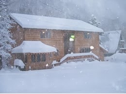 Exterior winter scene with Christmas lights, wreaths, and trimming along the deck and gazebo.