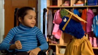 Professor Grover and a little girl are talking. Sesame Street Preschool is Cool ABCs With Elmo.