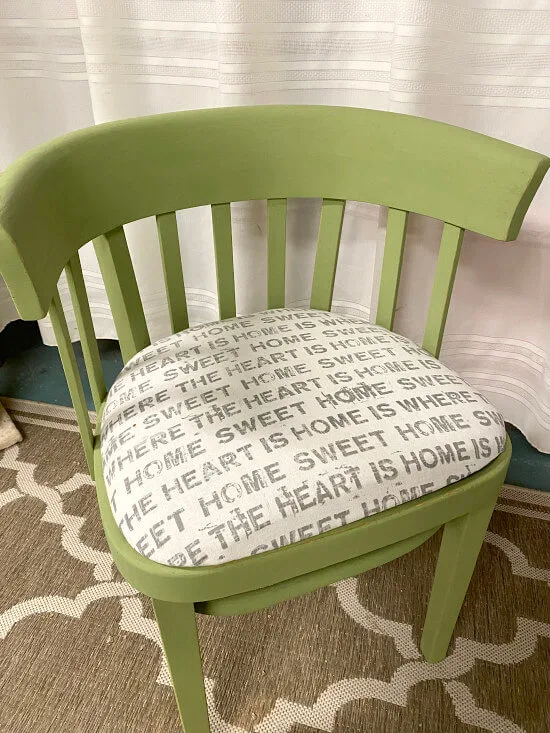 Green antique chair with black and white font fabric