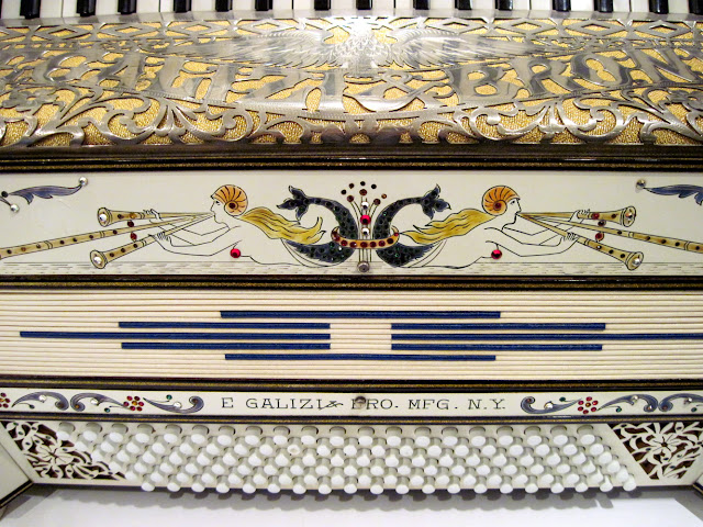 The E. Galizi Bro. White-and-Gold Pearled Piano Accordion is under lock and key at the Old New York Accordian Museum