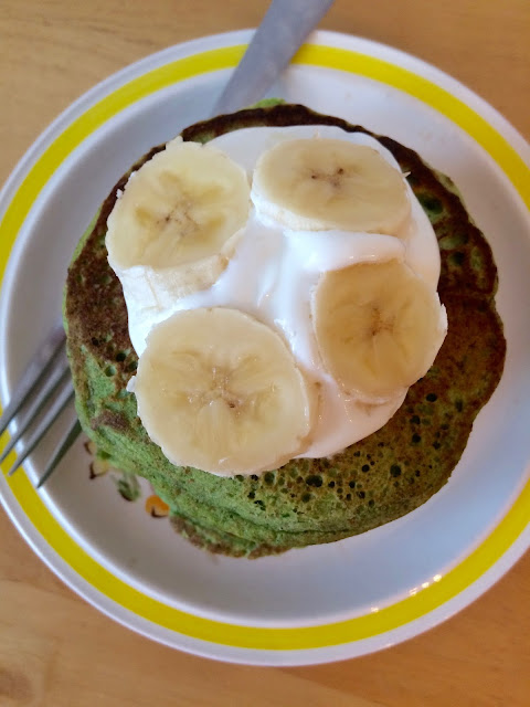 Spinach pancakes topped with yogurt and sliced banana.