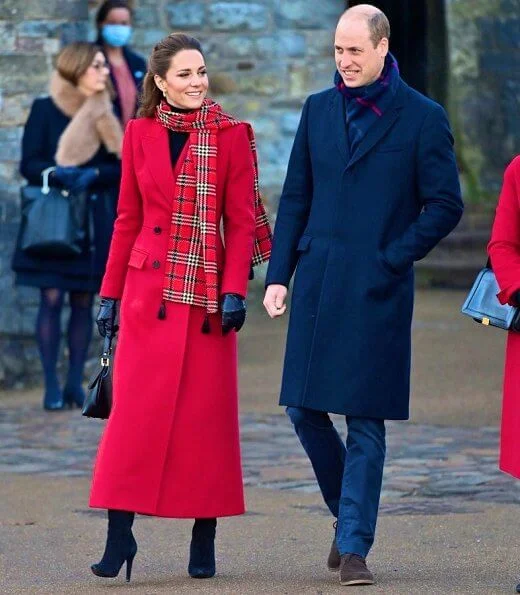 Kate Middleton wore a tartan pleated skirt from Emilia Wickstead, yellow gold hoops from Spells of Love. Alexander McQueen red coat. Grace Han bag