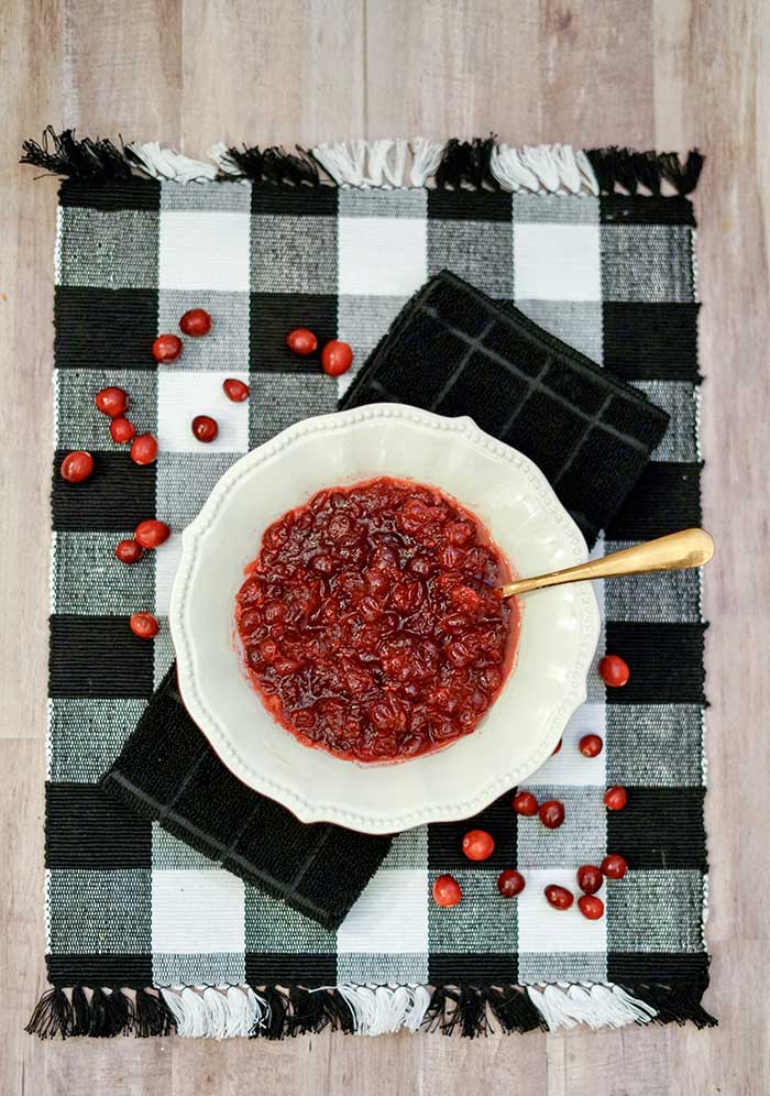 How to make apple cider cranberry sauce.  This easy recipe uses fresh cranberries and apple cider. It's sweet and perfect for Thanksgiving or any day. This is a great make ahead side dish for turkey, chicken, or ham.  Give a new twist to traditional cranberry sauce. This simple recipe is an easy homemade side dish.  Also includes uses for cranberry sauce. #thanksgiving #recipe #cranberry #cranberrysauce