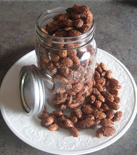 Cinnamon sugared almonds spilling out of a mason jar onto a white plate