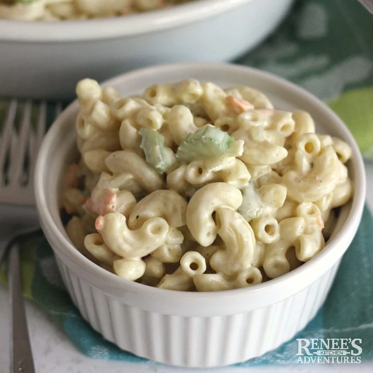 Amish Macaroni Salad by Renee's Kitchen Adventures close up serving in a white bowl with larger bowl in background
