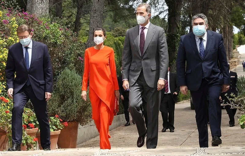 Queen Letizia wore an orange asymmetric outfit from Zara, and she carried red clutch by Angel Schlesser