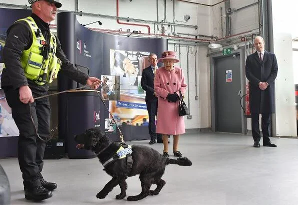 Queen Elizabeth wore a pink coat by Stewart Parvin and matching hat by Rachel Trevor-Morgan. Carved Ruby, gold and diamond brooch, Grima ruby brooch