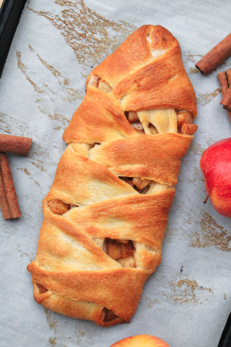 Cinnamon Apple Crescent Braid | The Two Bite Club | #feastndevour #crescentrolls Golden crescent rolls are braided around a sweetened cream cheese and cinnamon apple filling in this pretty Cinnamon Apple Crescent Braid that can be served as breakfast or a dessert!