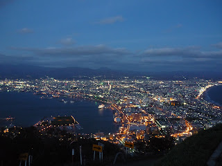 Nightview of Hakodate and it's sparkling lights and ocean from Mt Hakodate with road in the foreground