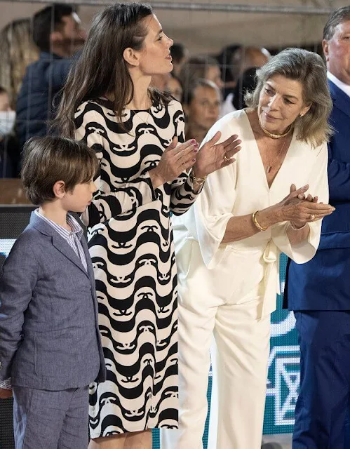 Princess Caroline wore a new wide short sleeve wrap front jumpsuit from Halston. Charlotte Casiraghi wore a new silk crepe dress from Chanel