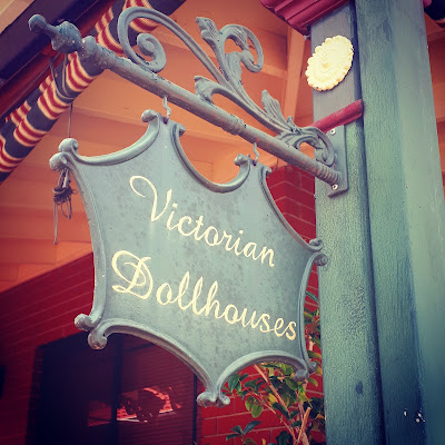 Hanging sign with 'Victorian Dollhouses' written on it.
