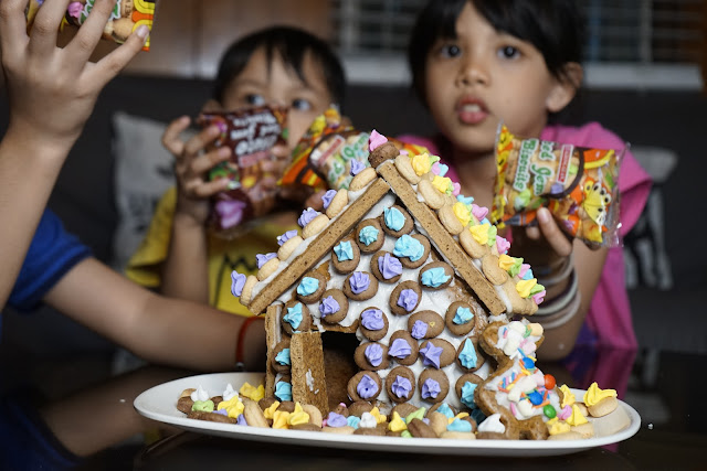 Decorating Gingerbread House With Iced Gems Biscuits