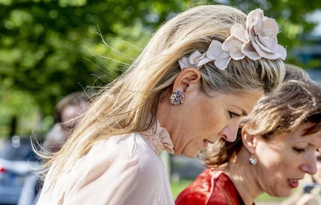 Queen Maxima wore a light baby pink tulle top and pink wide leg trousers. Salvatore Ferragamo flower heel pump shoe