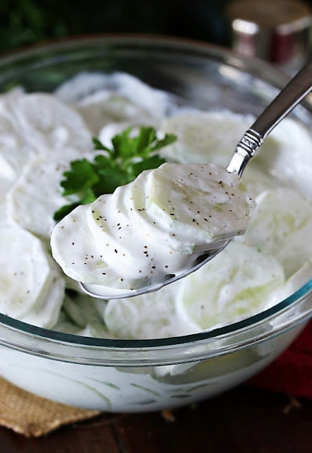 Serving Spoon of Cucumbers in Sour Cream Image