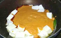 Pouring tomato onion puree to cook paneer makhani recipe