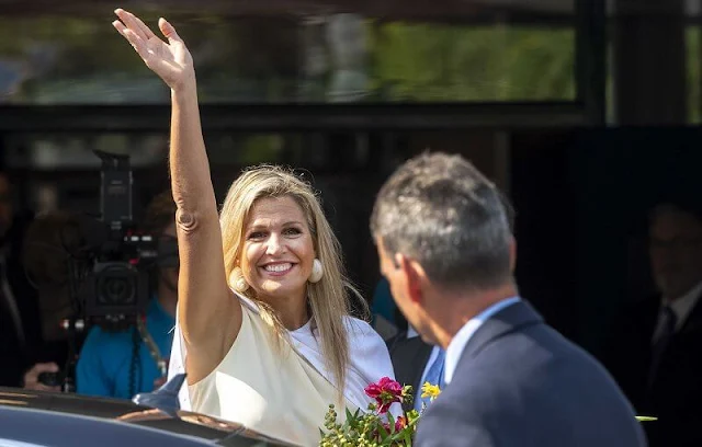 Queen Maxima wore gold tone and shell clip earrings by Prada. Queen Maxima wore a sleeveless high neck silk shirt by Zara, Natan