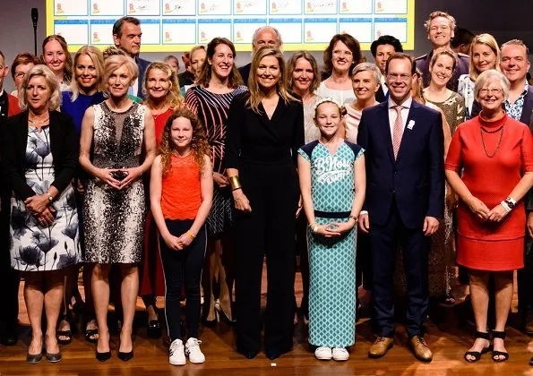 Queen Maxima wore Natan Crepe Jumpsuit, Natan gold earrings, and she carried Natan clutch bag for More music in the classroom' meeting