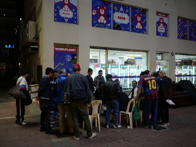 Crowd surrounding two people playing xiangqi