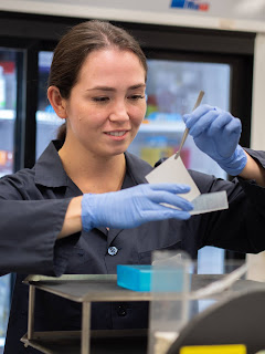Khayrullina in a lab setting examining an experiment.