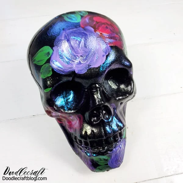 Halloween Skull #3: Loose Florals  I think my most favorite thing in the world, besides pizza and dark chocolate, is loose florals. They are so much fun to paint! They take pretty much zero skill and look fabulous!  Just pick the colors of paint to match your decor and party and use a round brush to apply the paint to the skull.   How to Paint Loose Florals: Step 1: Pick a dark shade of paint and use a round brush to glob "C" shaped petals around in a circle...loosely resembling a rose.  Step 2: Pick a light shade of paint and use a round brush to glob "C" shaped petals around the dark petals painted. Work while dark paint is still wet to allow for some blending.  Step 3: Pick a green paint and add "tear" drop or "leaf" shapes for leaves, typically done in one or two strokes with a round brush.  Step 4: Add some Dragonfly Glaze or Metallic FolkArt paint to add shimmer to the flowers just painted.