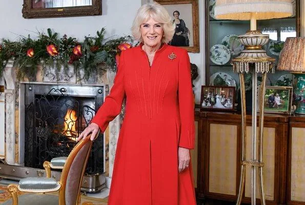 The Duchess of Cornwall wears a red wool coatdress by designer Fiona Clare